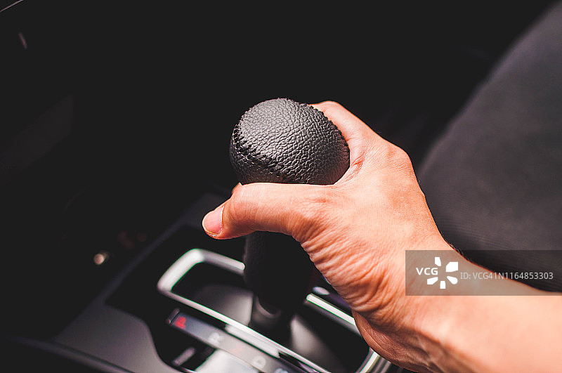 年轻男人握着自动挡变速杆图片素材