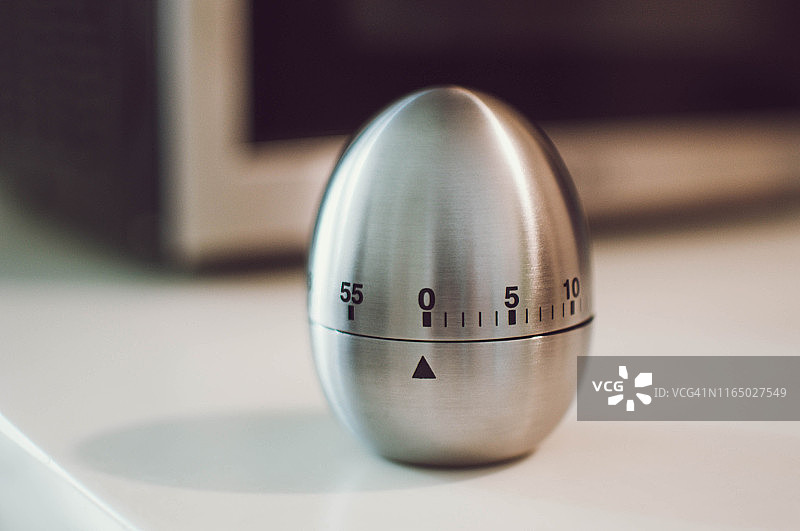 厨房桌子上的金属鸡蛋厨房定时器图片素材