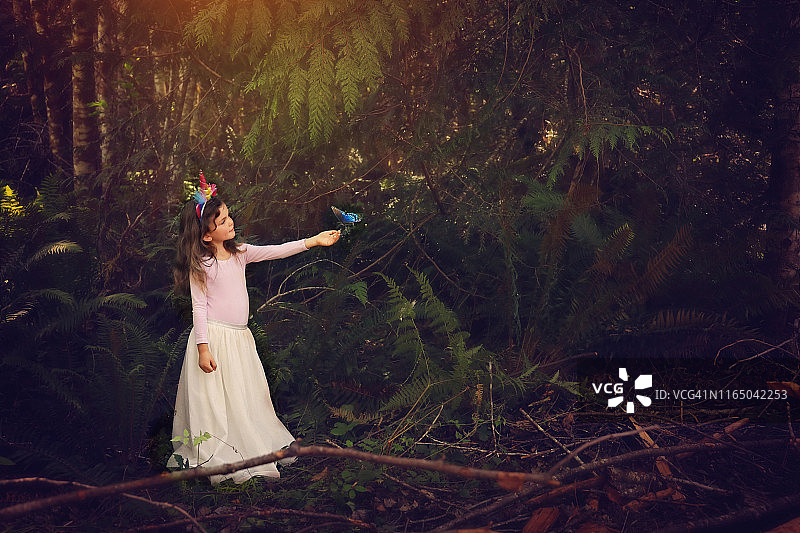 在森林里与蝴蝶玩耍的5岁女孩图片素材