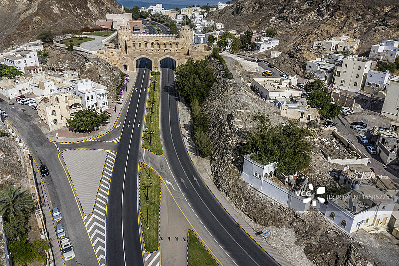 阿曼马斯喀特老城区，Al Bahri公路两条车道从马斯喀特门下方穿过的航拍图片素材