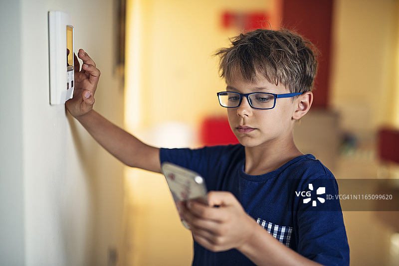 小男孩将智能手机与智能家居系统配对图片素材