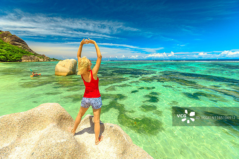 塞舌尔拉迪格岛银泉滩红裙女游客图片素材