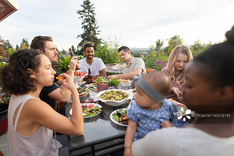 一群年轻朋友在露台上用餐图片素材