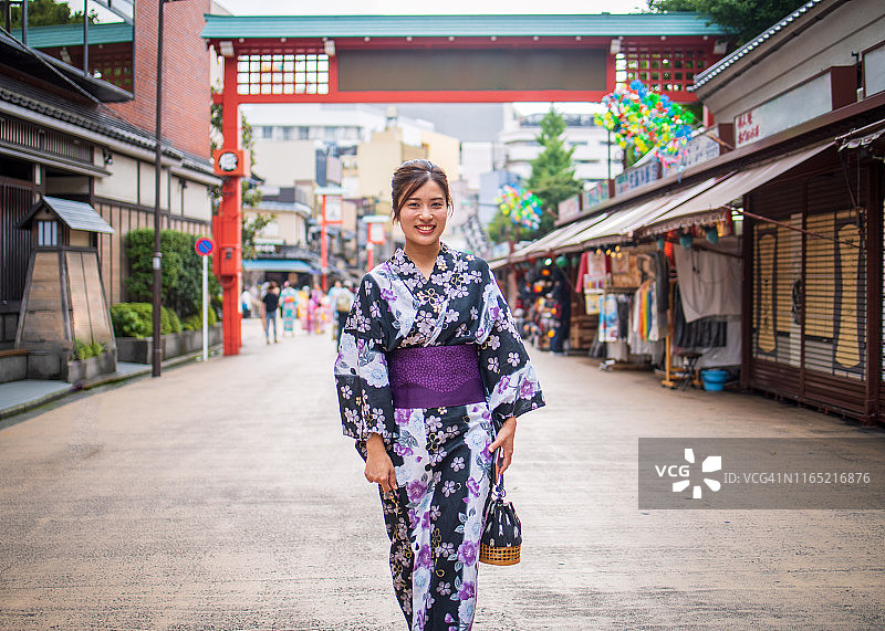 身穿浴衣的年轻女子走在日本传统街道上图片素材