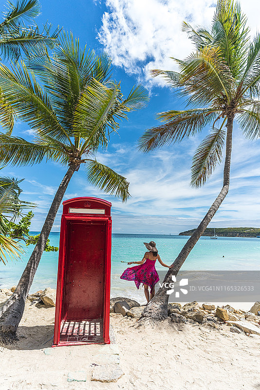 优雅女人在安提瓜锡伯尼海滩电话亭旁图片素材