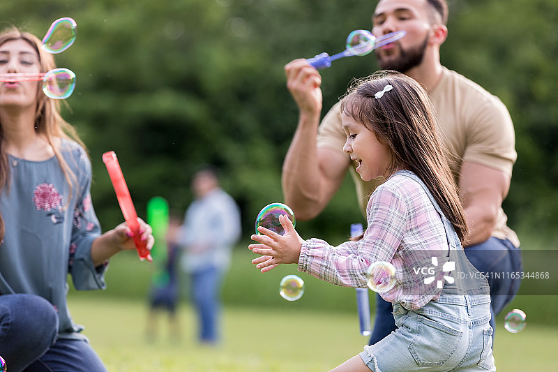 可爱小女孩在公园里追逐泡泡图片素材
