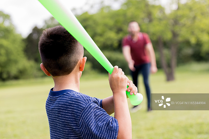 家庭棒球比赛中，小男孩准备击球图片素材