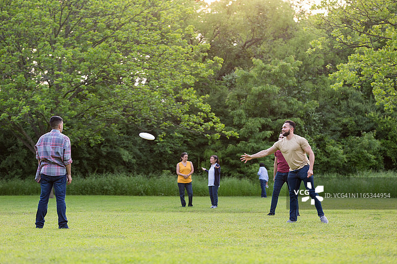女士聊天，男士玩飞盘图片素材