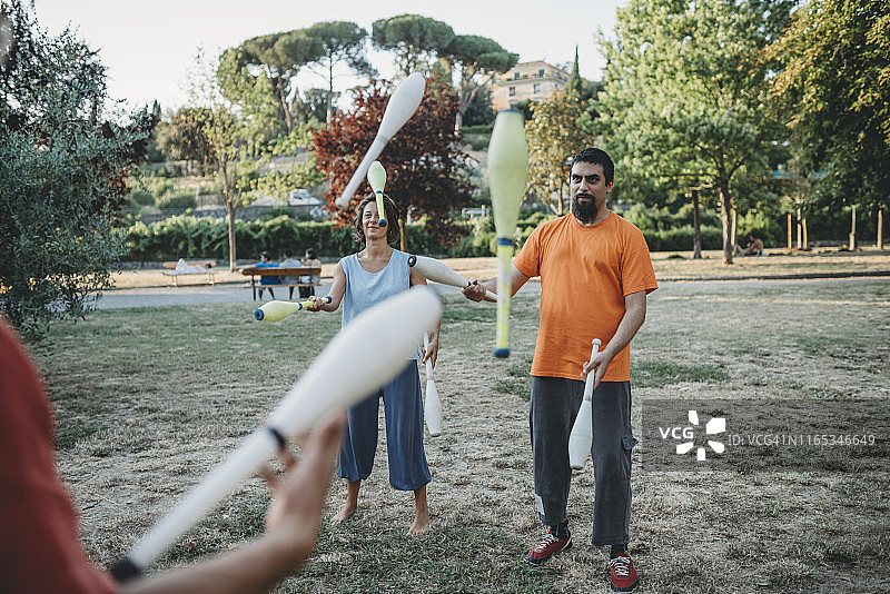 三位年轻的杂耍演员在公园一起训练图片素材