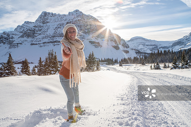 跟随我概念：快乐的年轻女子带领男友在日落时分前往雪山图片素材