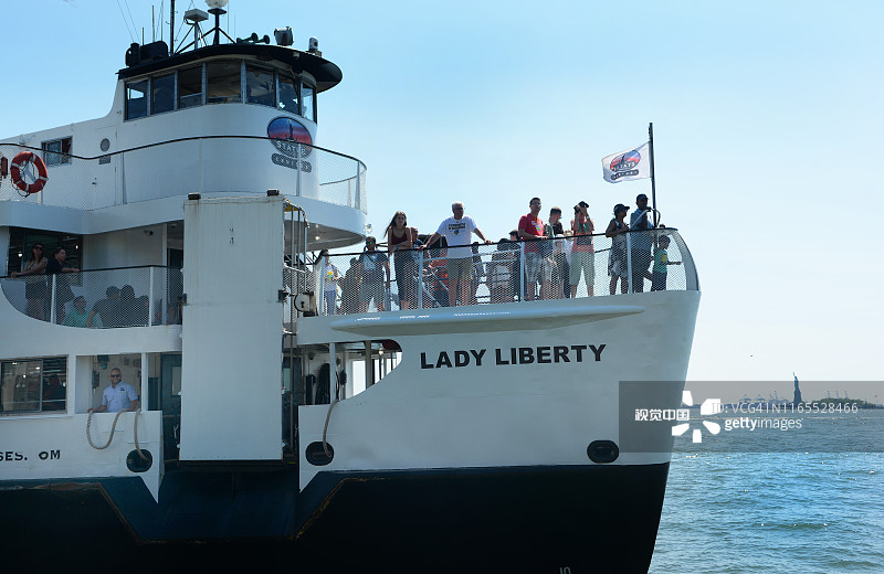自由女神像游轮的自由女神岛渡轮，背景是纽约市的自由女神像图片素材
