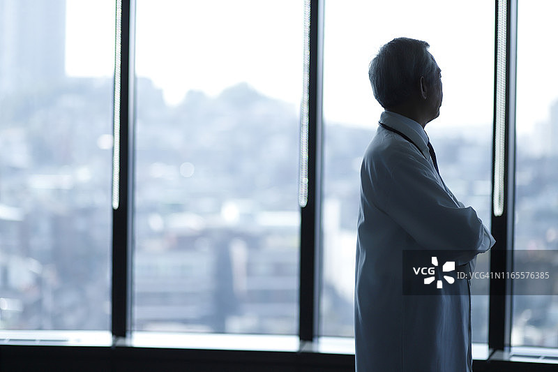 医生透过医院的窗户向外看图片素材