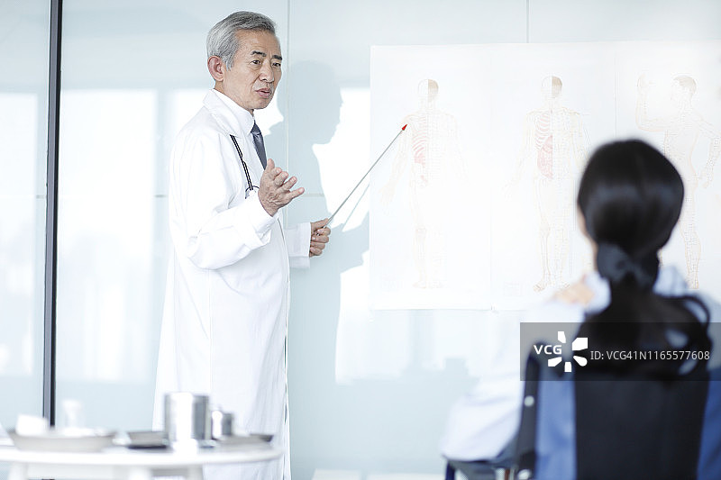 医生讲解患者的肩部疼痛图片素材