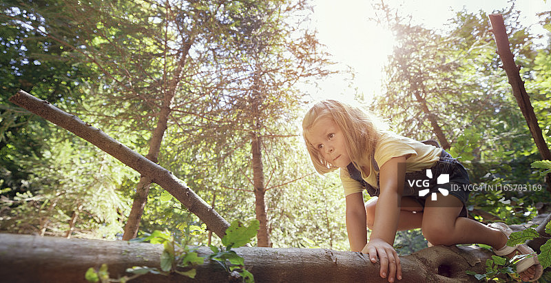 爬倒下的树的女孩图片素材