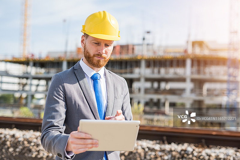 在建筑工地使用平板电脑的年轻工程师图片素材