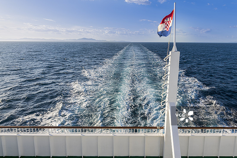 从科尔丘拉岛维拉卢卡到斯普利特的渡轮船尾飘扬的克罗地亚国旗图片素材