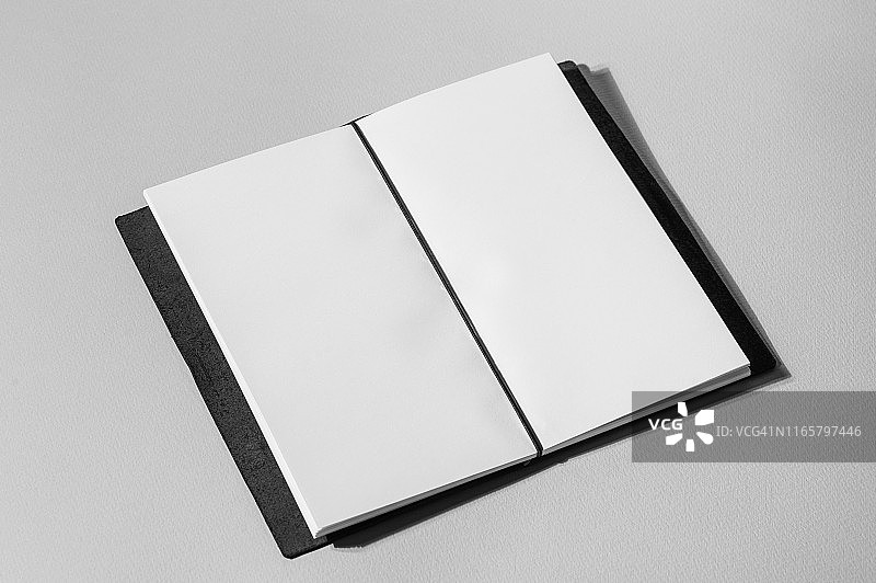 灰色背景上带有空白页面的打开的书本图片素材