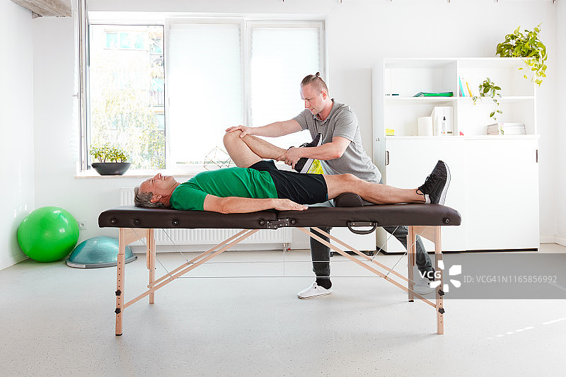 理疗师为男子进行腿部康复图片素材