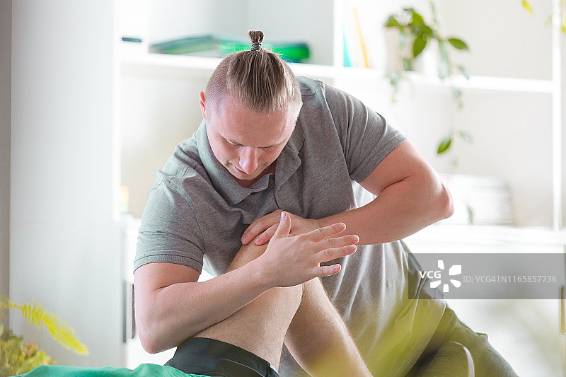 理疗师为男子按摩腿部图片素材