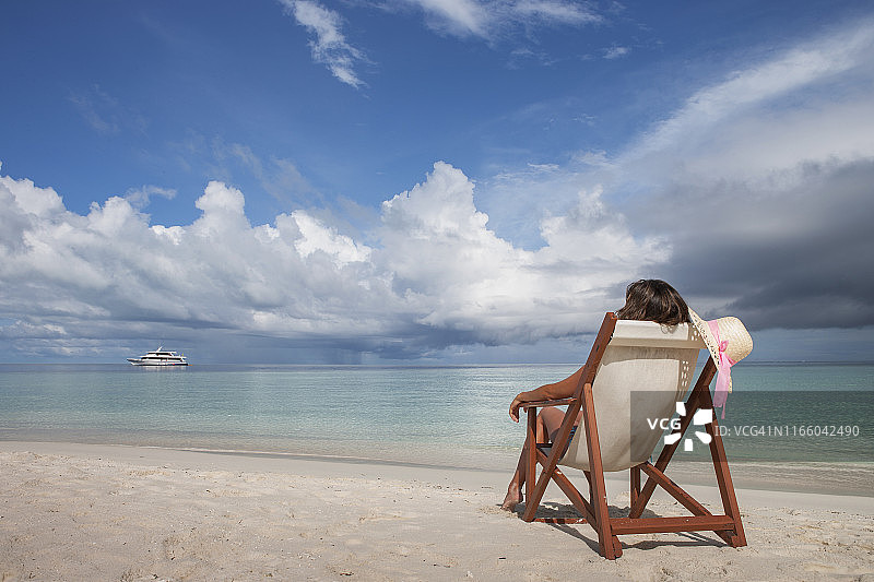 躺在热带海滩躺椅上的女人图片素材