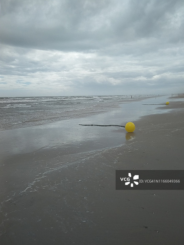 阴天下的蓬塔翁布里亚海滩风景与黄色浮标图片素材
