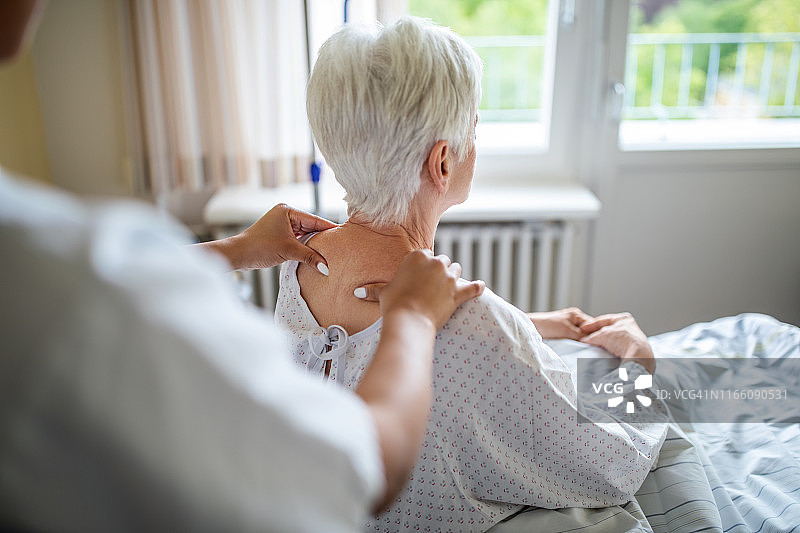理疗师为年长女性按摩肩部图片素材
