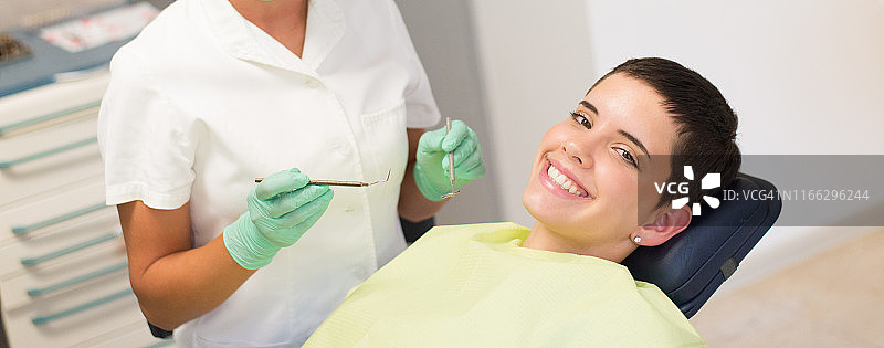 年轻微笑的女人在牙医诊所图片素材
