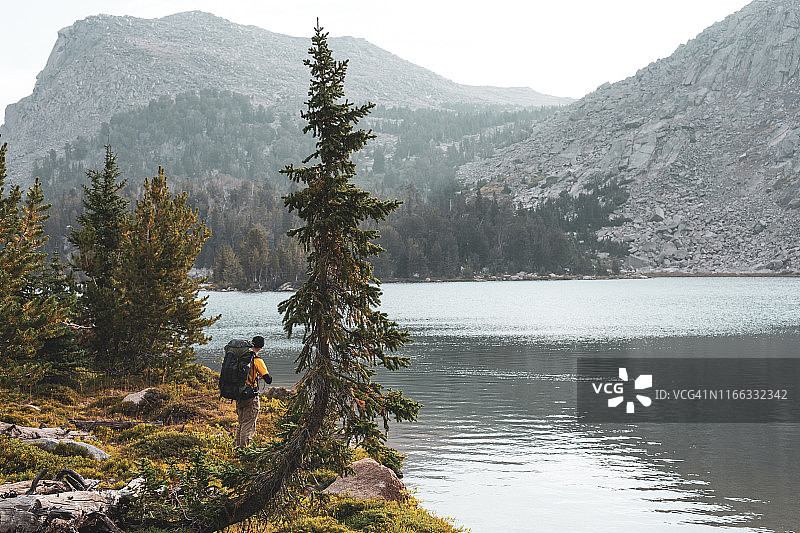 徒步旅行者站在高山湖泊旁，美国怀俄明州图片素材
