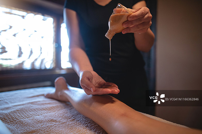 女按摩师将精油倒在手掌上图片素材