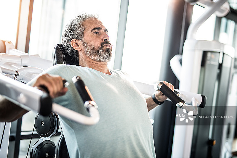 中年男人在健身房做胸部运动图片素材
