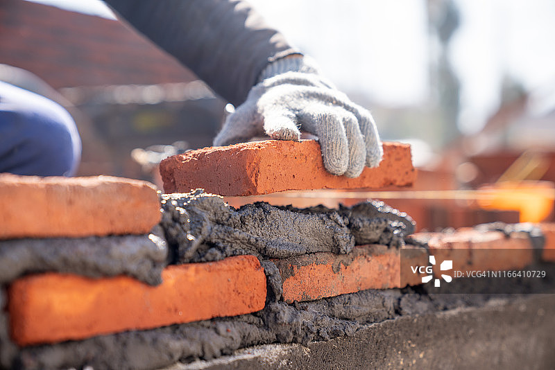 建筑工人在施工现场用泥刀安装砖砌体图片素材