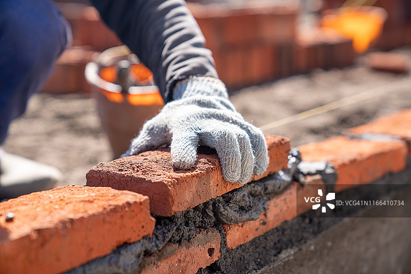 建筑工人在施工现场用泥刀安装砖砌体图片素材