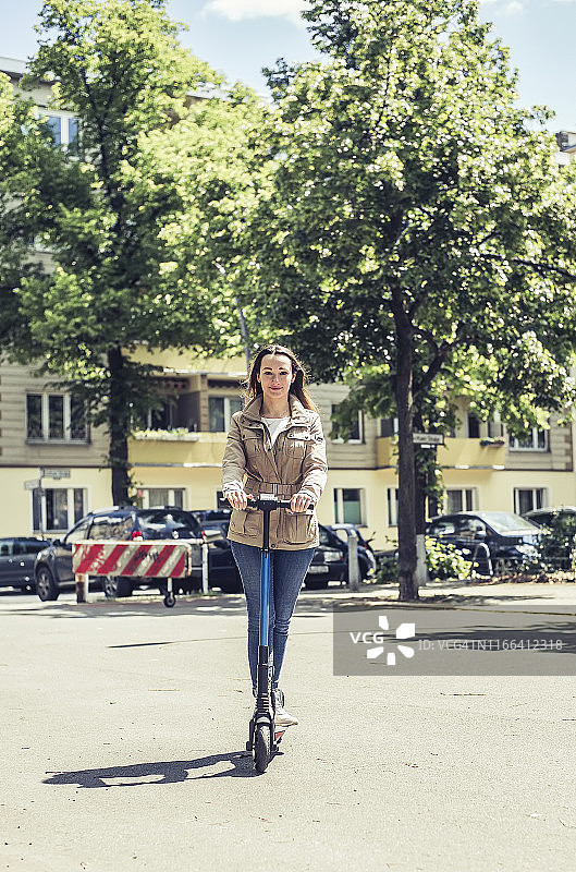 骑电动滑板车的微笑女性图片素材