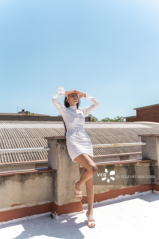屋顶上穿着时尚白裙的女人图片素材