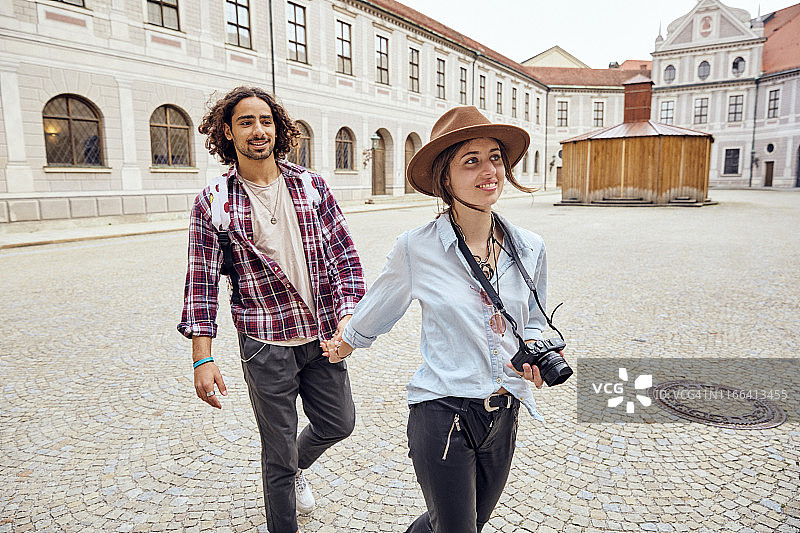 年轻情侣在德国慕尼黑王宫庭院中漫步图片素材