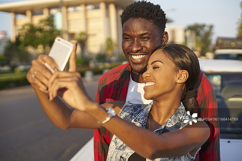 年轻情侣用智能手机自拍，莫桑比克马布多图片素材