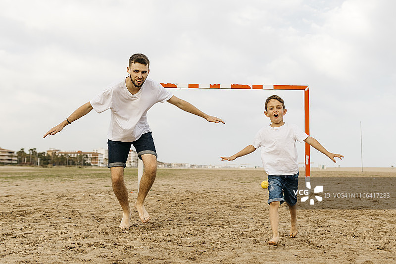 沙滩上庆祝进球的足球运动员图片素材