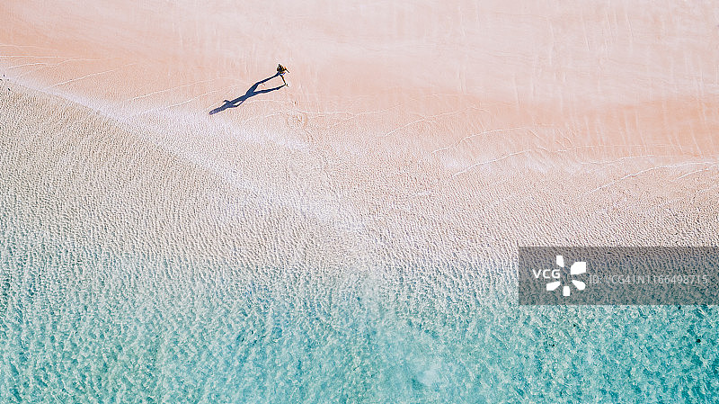 澳大利亚海滩上奔跑的女孩的无人机影像图片素材