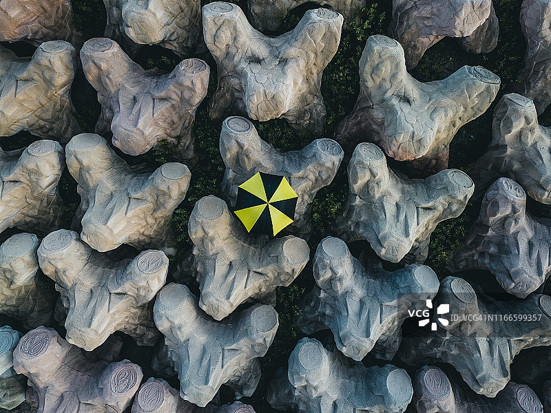 意大利因佩里亚，站在防波堤上撑伞的人的航拍图像图片素材