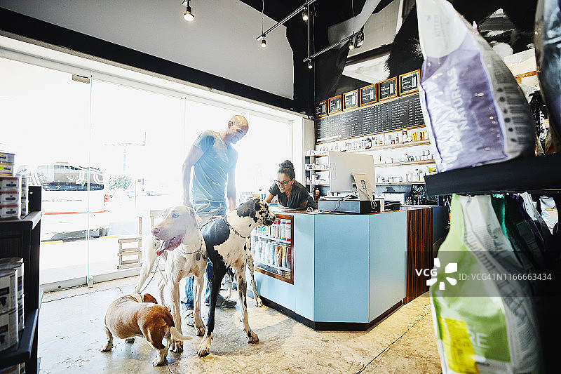 宠物店主抚摸顾客的宠物狗图片素材