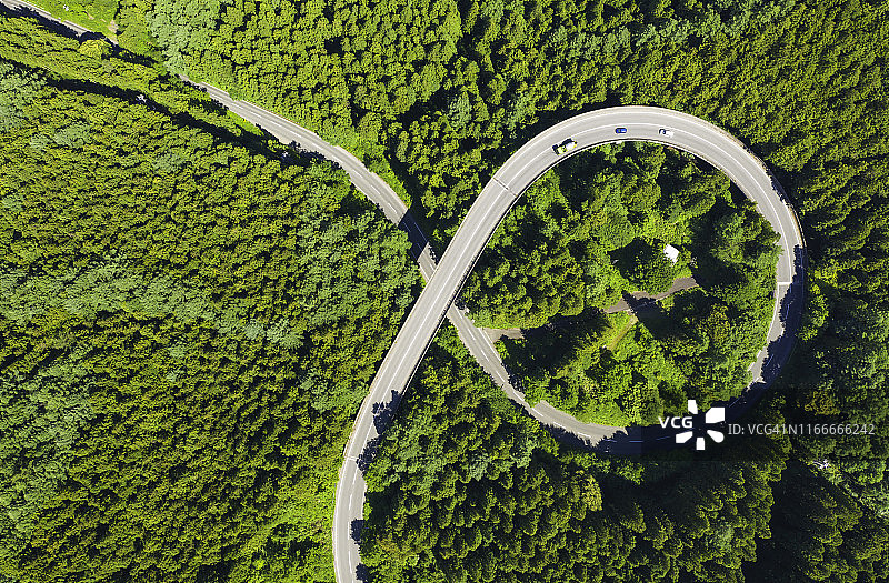 夏季山间绿林弯曲道路航拍视角图片素材