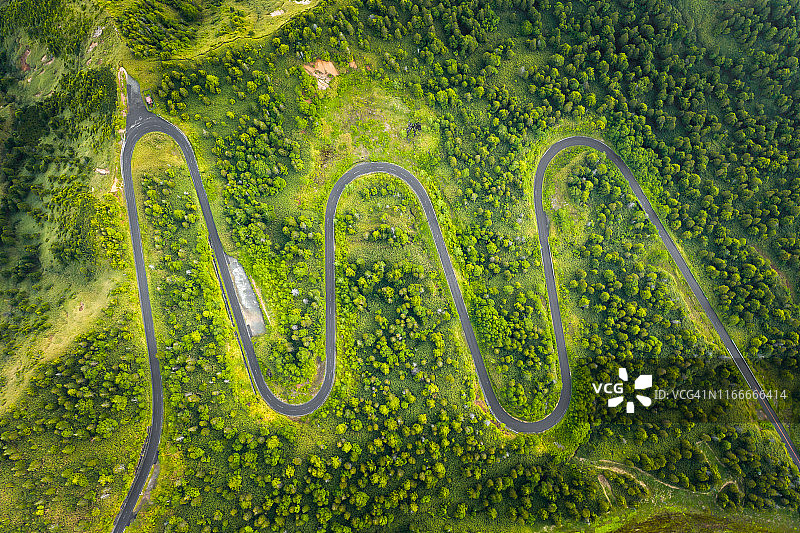 夏季山间绿林弯曲道路航拍视角图片素材