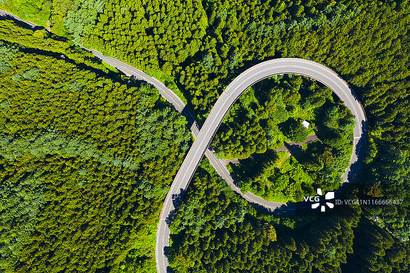 夏季山间绿林弯曲道路航拍视角图片素材