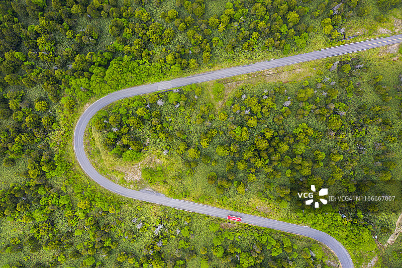 夏季山间绿林弯曲道路航拍视角图片素材