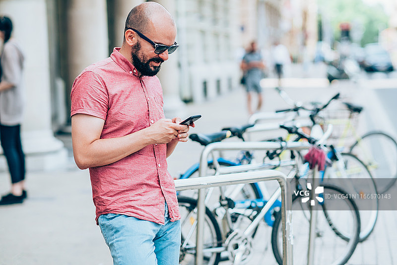 在城市里使用智能手机的年轻男人图片素材