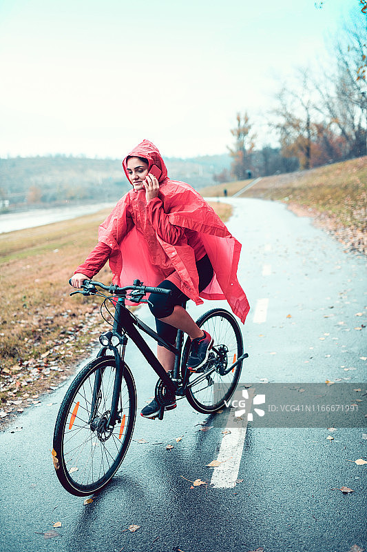 骑自行车的女人在骑车时打电话图片素材