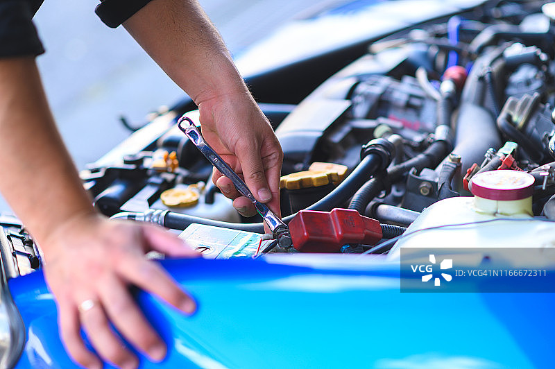 机械师维护汽车电池的局部手部照片图片素材