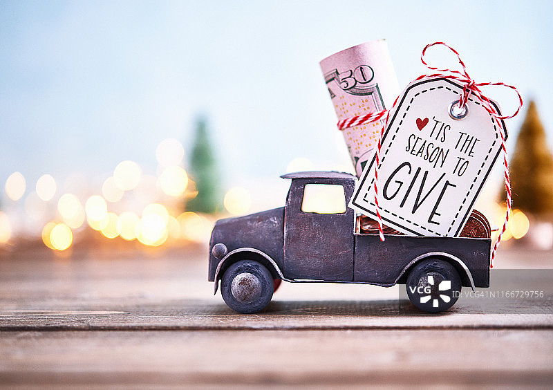 馈赠的季节：卡车运载着成卷美元与节日背景图片素材