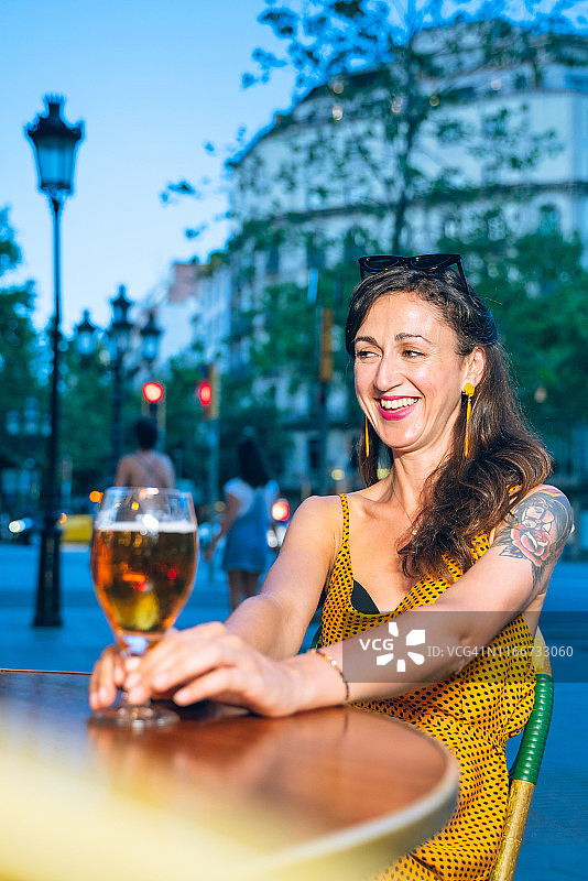在巴塞罗那格拉西亚大道喝啤酒的美丽女人图片素材