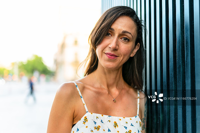 倚靠在金属墙上的美丽女人图片素材